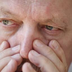 man holding nose due to allergies
