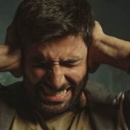 Overstimulated man holding ears