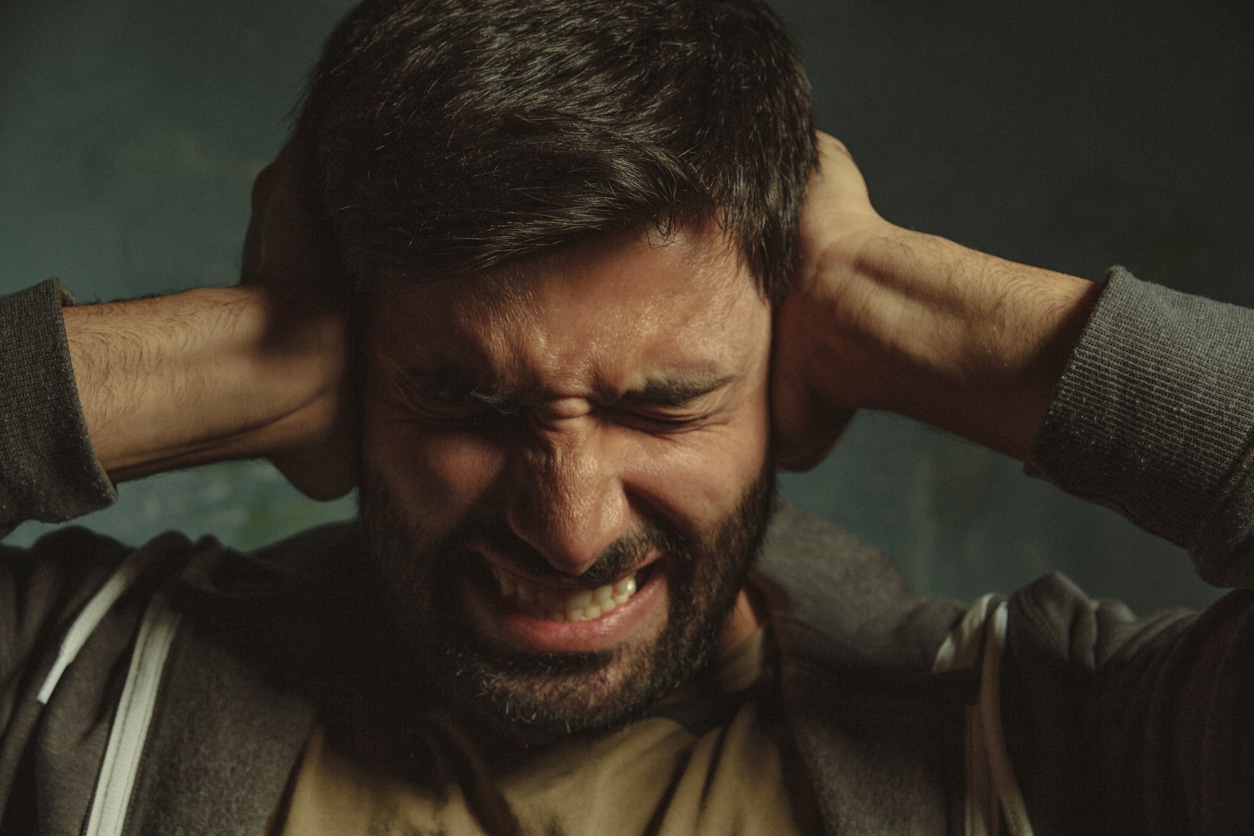 Overstimulated man holding ears