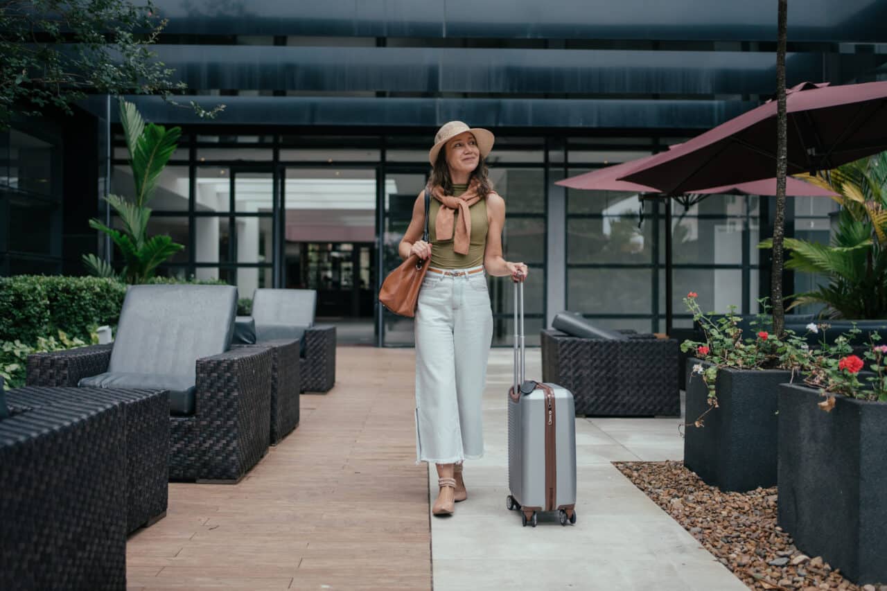 Woman confidently pushes her suitcase while traveling