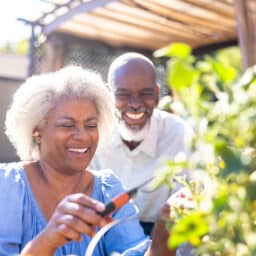 Senior man and woman with hearing aids enjoying nature.