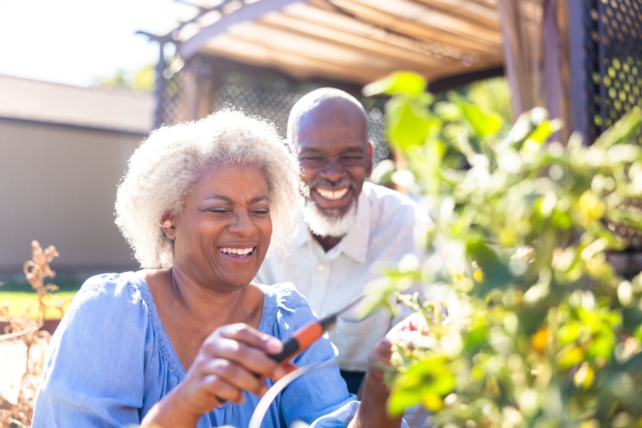 Senior man and woman with hearing aids enjoying nature.