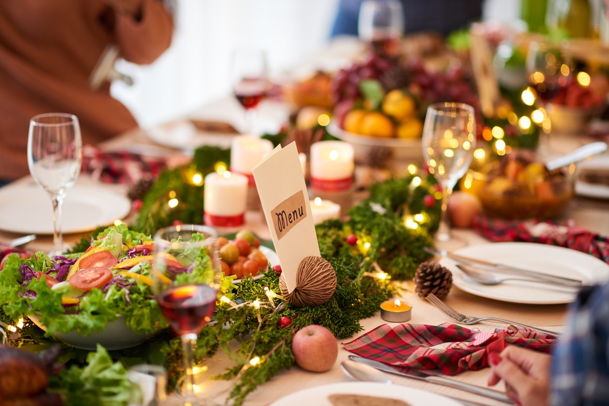 Holiday table setting with evergreen branches and candles