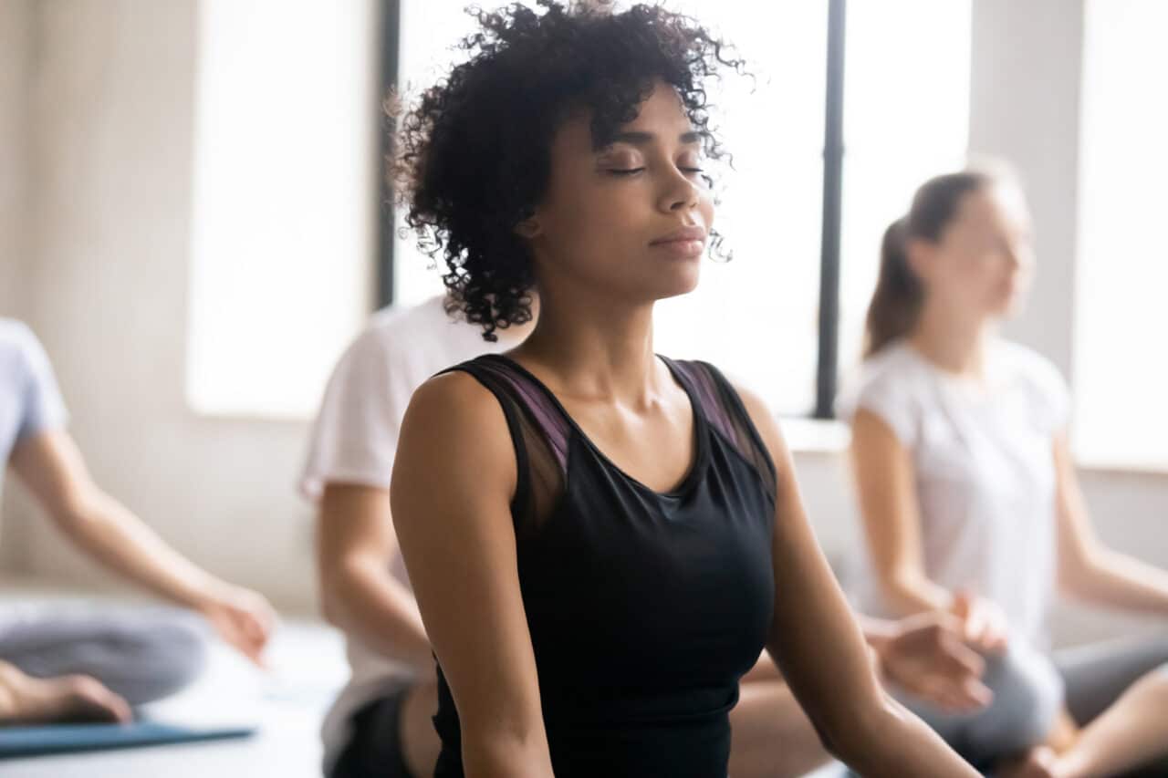 Close-up of woman in a meditation class, meditating peacefully.