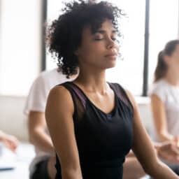 Close-up of woman in a meditation class, meditating peacefully.