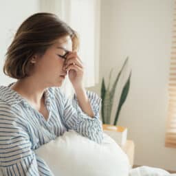 Woman having difficulty sleeping due to congestion from allergies.
