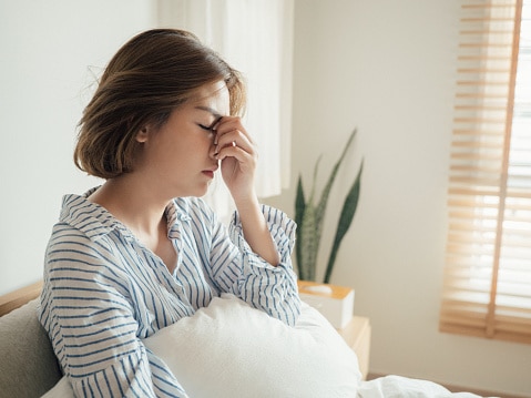 Woman having difficulty sleeping due to congestion from allergies.